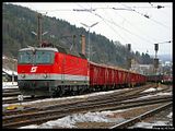 Die 1044.124 verlässt mit einem Holzzug die Güterzuggruppe von Mürzzuschlag.